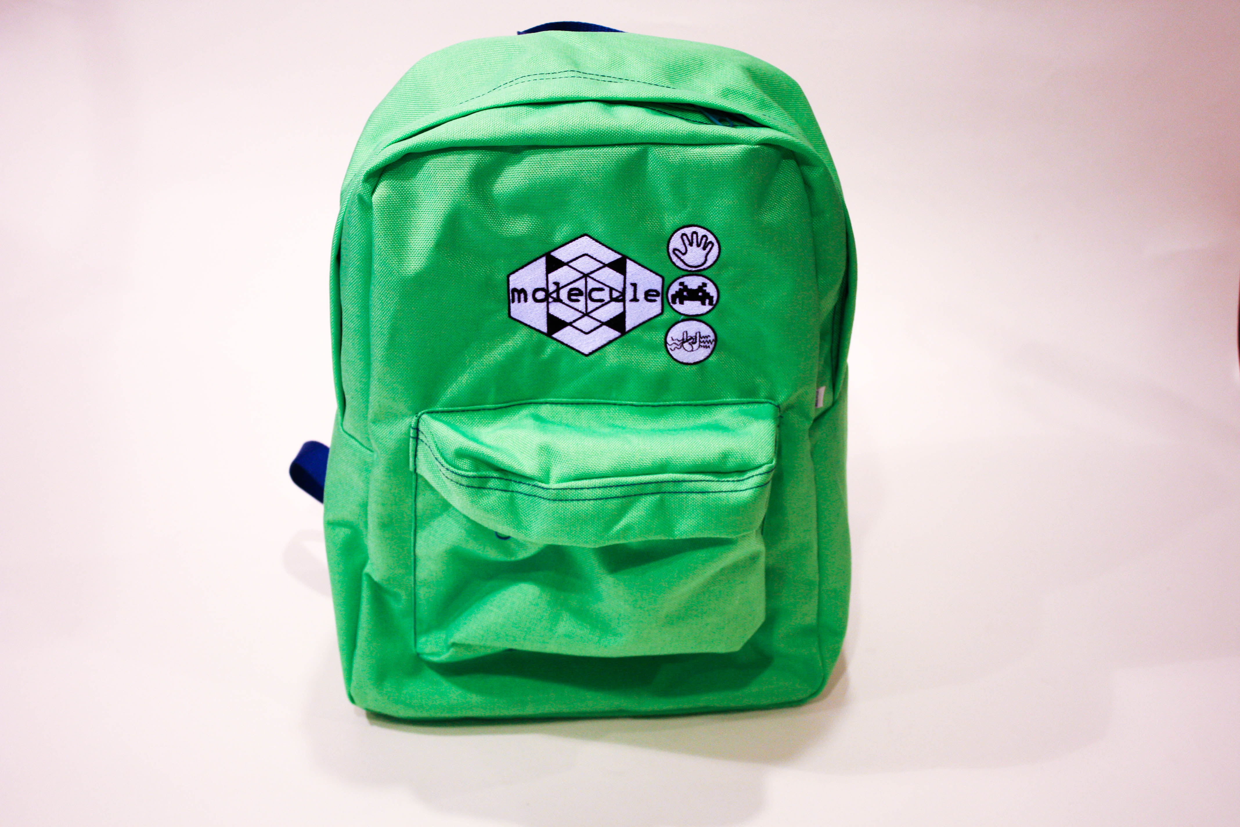 Bright green Molecule backpack with embroidered geometric logo and controller symbols.